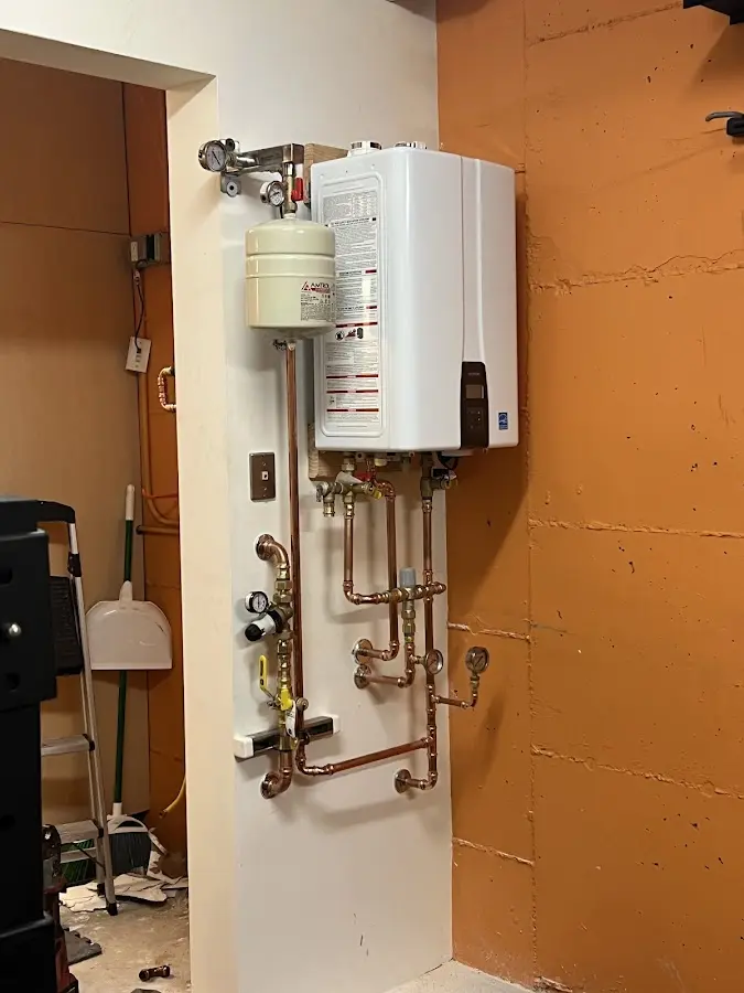 Plumbing technician inspecting water heater connections in Woodinville